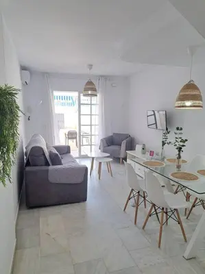a living room with a couch and a table at Dúplex 4, primera línea de Playa in Sanlúcar de Barrameda