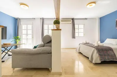 a bedroom with a bed and a couch at Sherry Suite Apartment - City Center in Jerez de la Frontera