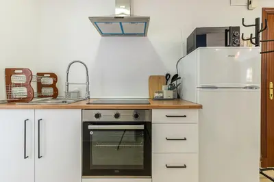 a kitchen with a stove and a refrigerator at Sherry Suite Apartment - City Center in Jerez de la Frontera