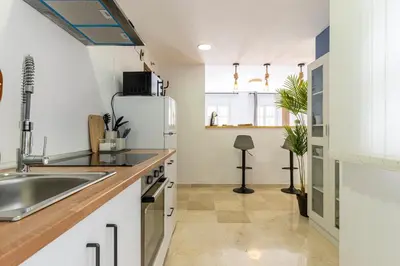 a kitchen with a sink and a refrigerator at Sherry Suite Apartment - City Center in Jerez de la Frontera