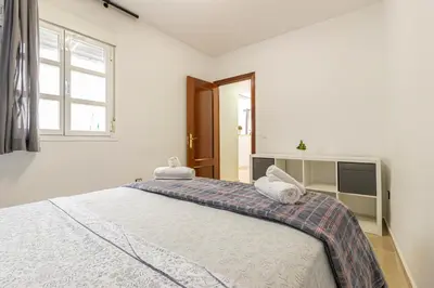a bedroom with a large bed with two towels on it at Sherry Suite Apartment - City Center in Jerez de la Frontera