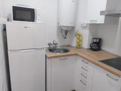 a small kitchen with a sink and a refrigerator at PLAYA LAS PILETAS-CALZADA in Sanlúcar de Barrameda