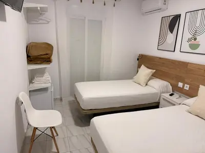 a small room with two beds and a chair at Hostal Merino Jédula in Jedula