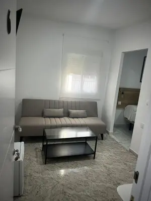 a living room with a couch and a coffee table at Hostal Merino Jédula in Jedula