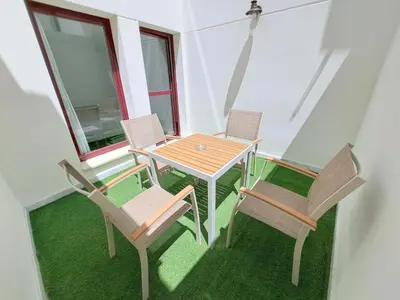 a table and chairs on a balcony with grass at Apartamentos Sherry Center in Jerez de la Frontera