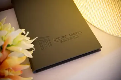 a book sitting on a table next to a flower at Apartamentos Sherry Center in Jerez de la Frontera