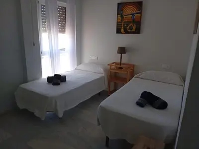 a room with two beds and a window at Ático con impresionantes vistas in El Puerto de Santa María
