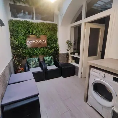 a living room with a couch and a washing machine at Jacuzzi Amazonas Relax en el Corazón del Puerto in El Puerto de Santa María