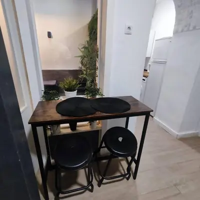a wooden table with two chairs and a table with two pillows at Jacuzzi Amazonas Relax en el Corazón del Puerto in El Puerto de Santa María
