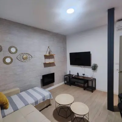 a living room with a couch and a flat screen tv at Jacuzzi Amazonas Relax en el Corazón del Puerto in El Puerto de Santa María