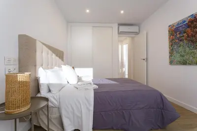 a white bedroom with a bed and a table at DELFIN Sunny Home by Cadiz4Rentals in Cádiz