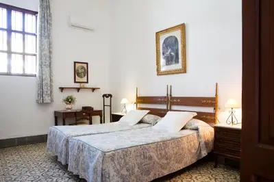 a hotel room with two beds and a window at CORTIJO RURAL LA MARISCALA in Jerez de la Frontera