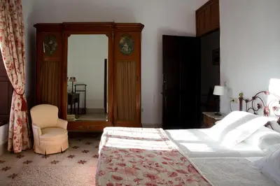a bedroom with a large bed and a mirror at CORTIJO RURAL LA MARISCALA in Jerez de la Frontera
