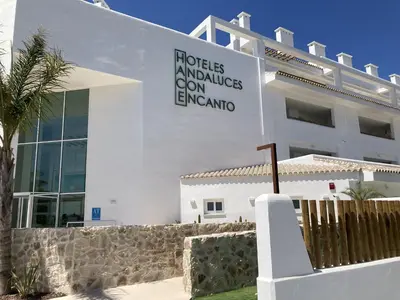 a white building with a sign on the side of it at Punta Candor Suites in Rota
