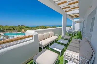 a balcony with chairs and a view of the ocean at Punta Candor Suites in Rota