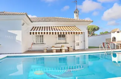 a villa with a swimming pool in front of a house at Chalet Cocle in Novo Sancti Petri