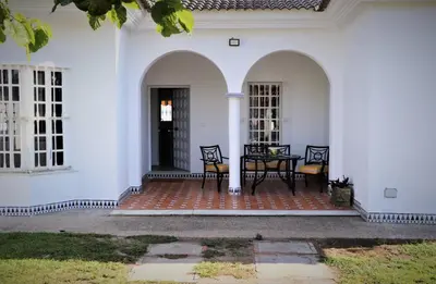 a porch of a white house with a table and chairs at Chalet Cocle in Novo Sancti Petri