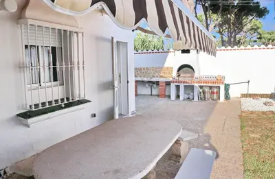 a bench sitting outside of a building with an awning at Chalet Cocle in Novo Sancti Petri