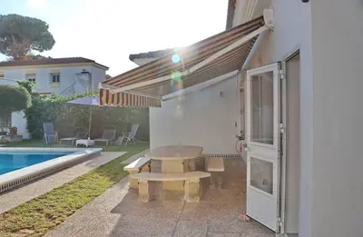 a picnic table and a bench next to a pool at Chalet Cocle in Novo Sancti Petri