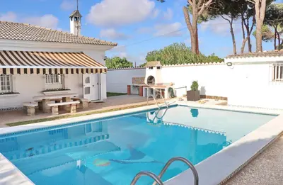 a swimming pool in front of a house at Chalet Cocle in Novo Sancti Petri