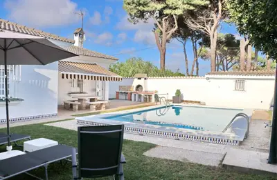 a swimming pool in a yard next to a house at Chalet Cocle in Novo Sancti Petri