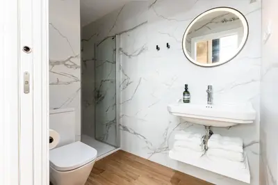 a white bathroom with a sink and a mirror at Villa de Paradas in Cádiz