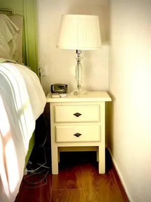 a nightstand with a lamp on it next to a bed at MyChoice Villa Almadraba in Rota