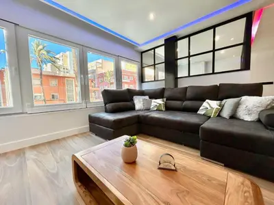 a living room with a black couch and windows at GATU PREMIUM Deseo Piso de Lujo con Parking 