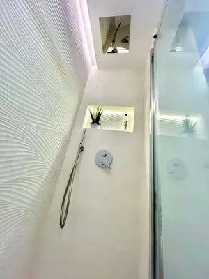a bathroom with a shower and a clock on the wall at GATU PREMIUM Deseo Piso de Lujo con Parking 
