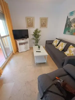a living room with a couch and a tv at Costa Ballena - El Paraíso in Rota