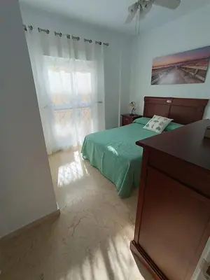 a bedroom with a green bed and a window at Costa Ballena - El Paraíso in Rota