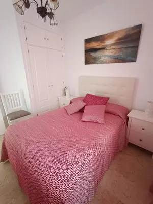 a bedroom with a bed with a red comforter at Costa Ballena - El Paraíso in Rota