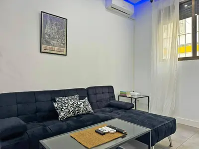 a living room with a black couch and a table at Apartamento Acebuche - Ole Solutions in Jerez de la Frontera