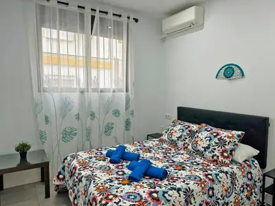 a bedroom with a bed with blue pillows at Apartamento Acebuche - Ole Solutions in Jerez de la Frontera