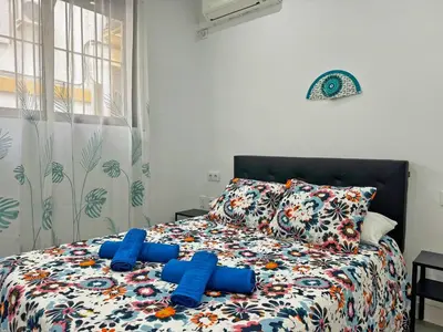 a bedroom with a bed with blue pillows at Apartamento Acebuche - Ole Solutions in Jerez de la Frontera