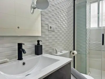 a white bathroom with a sink and a shower at Apartamento Acebuche - Ole Solutions in Jerez de la Frontera