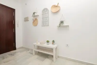 a white room with a table and plants on the wall at Verano en Chiclana in Chiclana de la Frontera