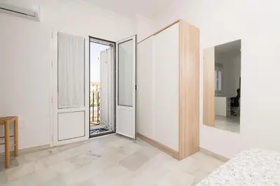 a room with white walls and large mirrors at Verano en Chiclana in Chiclana de la Frontera