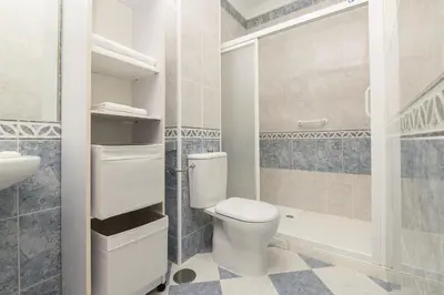 a bathroom with a toilet and a sink and a shower at Verano en Chiclana in Chiclana de la Frontera