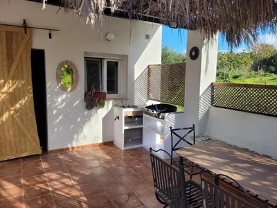 a patio with a table and chairs and a kitchen at casa entre mer et montagne in Arcos de la Frontera