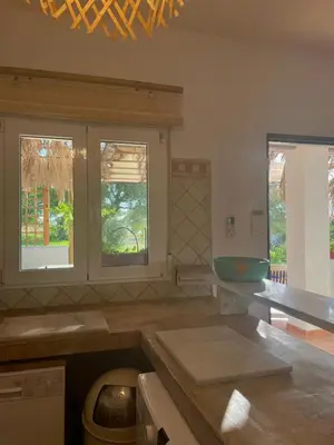 a kitchen with a sink and two windows at casa entre mer et montagne in Arcos de la Frontera