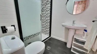 a bathroom with a toilet and a sink and a mirror at RESIDENCIAL VICTORIA CENTRO in Sanlúcar de Barrameda