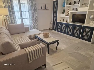 a living room with a couch and a table and a tv at RESIDENCIAL VICTORIA CENTRO in Sanlúcar de Barrameda