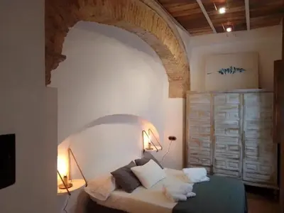 a room with a bed with an archway in it at La gota de leche 1 in Sanlúcar de Barrameda