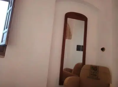 a mirror in a room with a couch and a chair at La gota de leche 1 in Sanlúcar de Barrameda