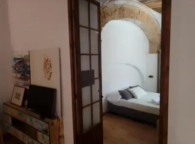 a bedroom with a bed and an open door at La gota de leche 1 in Sanlúcar de Barrameda