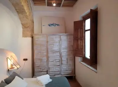 a bedroom with a bed and a window and a dresser at La gota de leche 1 in Sanlúcar de Barrameda