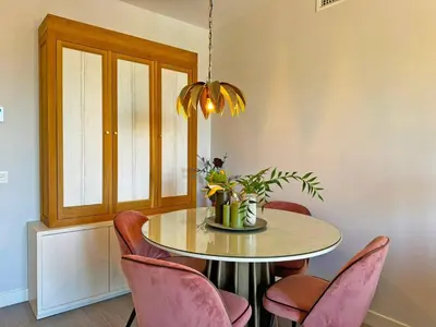 a dining room with a table and pink chairs at Apartamento Moscatel - Ole Solutions in Jerez de la Frontera