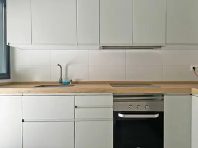a kitchen with white cabinets and a black oven at Apartamento Moscatel - Ole Solutions in Jerez de la Frontera