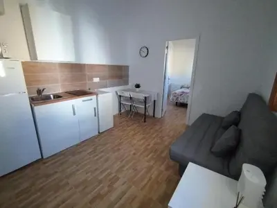 a living room with a couch and a kitchen and a table at APARTAMENTO CAMPANA-6 in Jerez de la Frontera